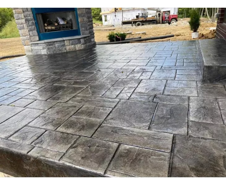 A concrete patio with a fire pit, providing a cozy outdoor space for relaxation and gatherings.